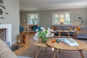 a living room with a vase of flowers on a table at Kampenherz - Traumhaftes Einzelhaus im Herzen von Kampen in Kampen +20 photos