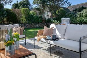 a patio with two white couches and a table at Kampenherz - Traumhaftes Einzelhaus im Herzen von Kampen in Kampen