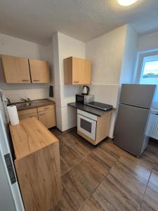 a small kitchen with a counter and a refrigerator at Apartment an der Weser in Bremerhaven