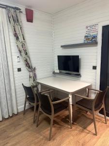 a table and chairs in a room with a television at premium park apart otel in Kemer