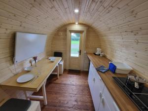 a kitchen with a whiteboard in a wooden wall at Campingpod in Südbrookmerland