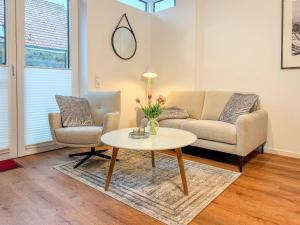 una sala de estar con un sofá y una mesa en Kraanstiet 2, en Zingst