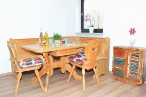 a wooden table with two chairs and a table with drinks on it at Winklstüberl in Grabenstätt