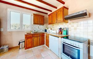 cocina con armarios de madera y horno de fogón blanco en 3 Bedroom Stunning Home In Bédoin, en Bédoin