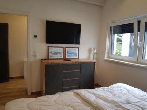 a bedroom with a bed and a flat screen tv at Ferienhaus Max in Rerik