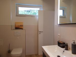 a bathroom with a toilet and a sink and a window at Ferienhaus Max in Rerik