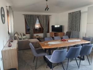 a living room with a table and chairs and a couch at Διαμέρισμα με θέα - Sunset House Lemnos in Agios Ioannis Kaspaka