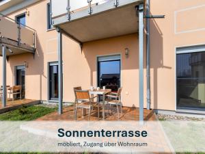 a patio with a table and chairs in front of a house at Peenemünde, Seglerhafen ST Brig 02 & 04 in Peenemünde