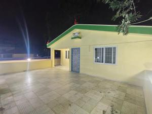 a small yellow building with a green roof at night at Yal Homestay in Yercaud +19 photos