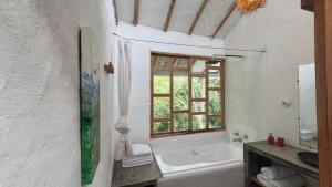 a white bathroom with a tub and a window at Casa Atamari in Salento