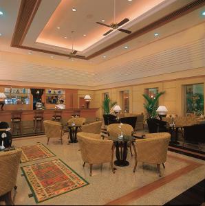 a living room filled with tables and chairs at Trident Cochin in Cochin