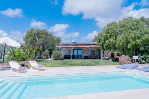 a villa with a swimming pool and a house at Casa Murina in Orosei