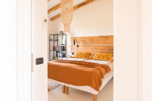 a bedroom with a bed with a wooden headboard at Casa Murina in Orosei +22 photos