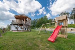 a playground with a slide and a tree house at Panoramabungalow Typ 70 in Truppach