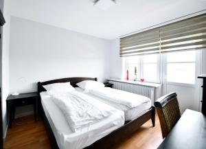 UtersumにあるHaus Windhuug Wohnung 4の白いシーツと窓のあるベッドのある寝室 +3枚の写真