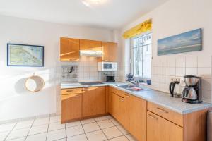 une cuisine avec des armoires en bois et un évier dans l'établissement Haus am Buchenpark 09, à Neuhof