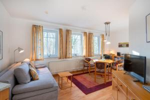 un salon avec un canapé et une télévision dans l'établissement Haus am Buchenpark 09, à Neuhof