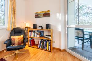 - un salon avec une chaise et une étagère dans l'établissement Haus am Buchenpark 09, à Neuhof