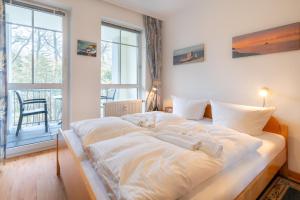 un grand lit blanc dans une chambre avec une fenêtre dans l'établissement Haus am Buchenpark 09, à Neuhof