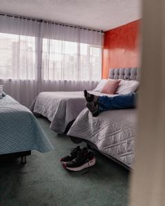 a bedroom with two beds with shoes on the floor at Innovar Casa Hostal in Bogotá