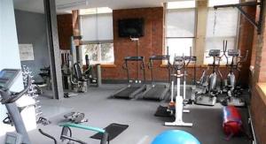 a gym with many exercise equipment in a room at Cityscape condos in Dewsbury