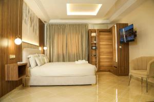a bedroom with a bed and a tv and a chair at Residence Issrae 1 in Nador