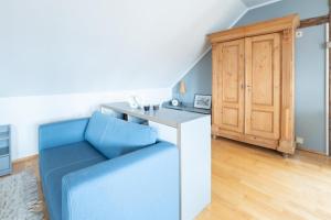 a living room with a blue couch and a desk at Dohna, App 116 in Pirna
