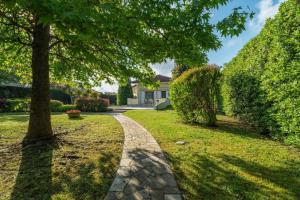 a walkway in front of a house with a tree at Diamante in Isola Albarella +20 photos