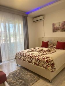 ein Schlafzimmer mit einem Bett mit roten Kissen in der Unterkunft Apartments Ardoni in Ulcinj