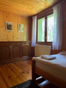 un dormitorio con una cama y una ventana en Domek w lesie, en Radogoszcz