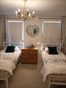 une chambre avec deux lits et un miroir dans l'établissement Mill cottage, à Carrickfergus 49 autres photos