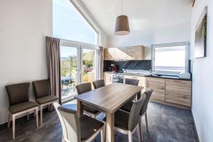 a kitchen and dining room with a wooden table and chairs at Ferienhaus Holunderweg an der Theme Obernsees mit Sauna in Truppach