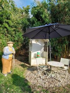 a statue of a woman standing next to a table and an umbrella at Landhaus Vreburg in Butjadingen