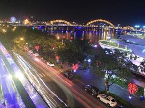 a city street at night with a bridge and cars at Han Riverside in Da Nang