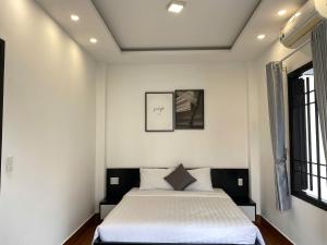 a bedroom with a bed in a white room at Han Riverside in Da Nang
