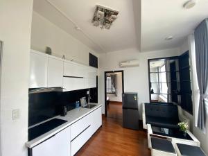 a kitchen with white cabinets and a black refrigerator at Han Riverside in Da Nang +2 photos