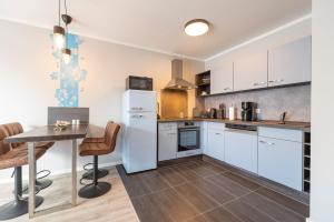 a kitchen with a table and a white refrigerator at Knuddi s Ferienhof, App 04 in Zempin