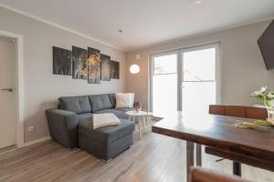 a living room with a couch and a table at Knuddi s Ferienhof, App 04 in Zempin