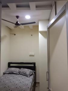 a bedroom with a bed and a ceiling fan at Sri Chaithra Guest Rooms in Guntūr +3 photos