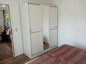 a bedroom with white cabinets and a mirror at Ferienwohnungen Evers 55181 in Stallbrüggerfeld