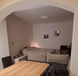 a living room with a bed and a table at Chambre dans maison paisible in La Ville-du-Bois