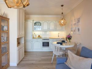 a kitchen with white cabinets and a table at Moin Sylt in Westerland (Sylt)