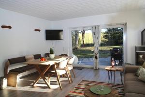 ネッセルヴァンクにあるFerienhaus Pamela im Feriendorf Reichenbach B23のテーブルとソファのあるリビングルーム +8枚の写真