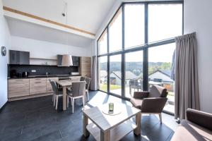 a kitchen and living room with a table and chairs at Panoramabungalow Typ 50 in Truppach