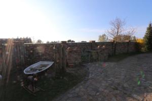 a man standing in a yard next to a brick wall at Am Rieck - Ferienhaus "GR 1904" in Zempin