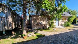 a house with a tree and a brick driveway at Am Rieck - Ferienhaus "GR 1904" in Zempin +29 photos