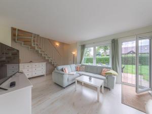 a living room with a couch and a staircase at Kornblume_DH in Groß Kelle
