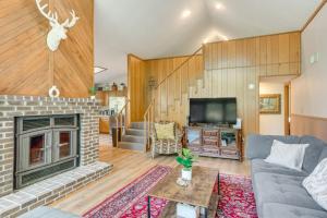 un salon avec une cheminée et une télévision dans l'établissement Pool Access Peaceful Cabin in The Woods Resort!, à Hedgesville