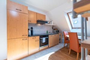 a kitchen with wooden cabinets and a table and chairs at Ackerweg, App 02 in Ueckeritz