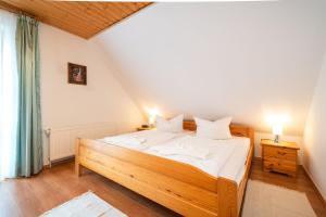 a bedroom with a large wooden bed with white sheets at Ackerweg, App 02 in Ueckeritz